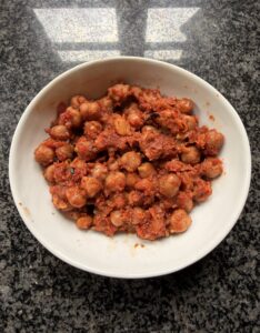 Spiced chickpeas in fire-roasted tomato sauce served in a white bowl